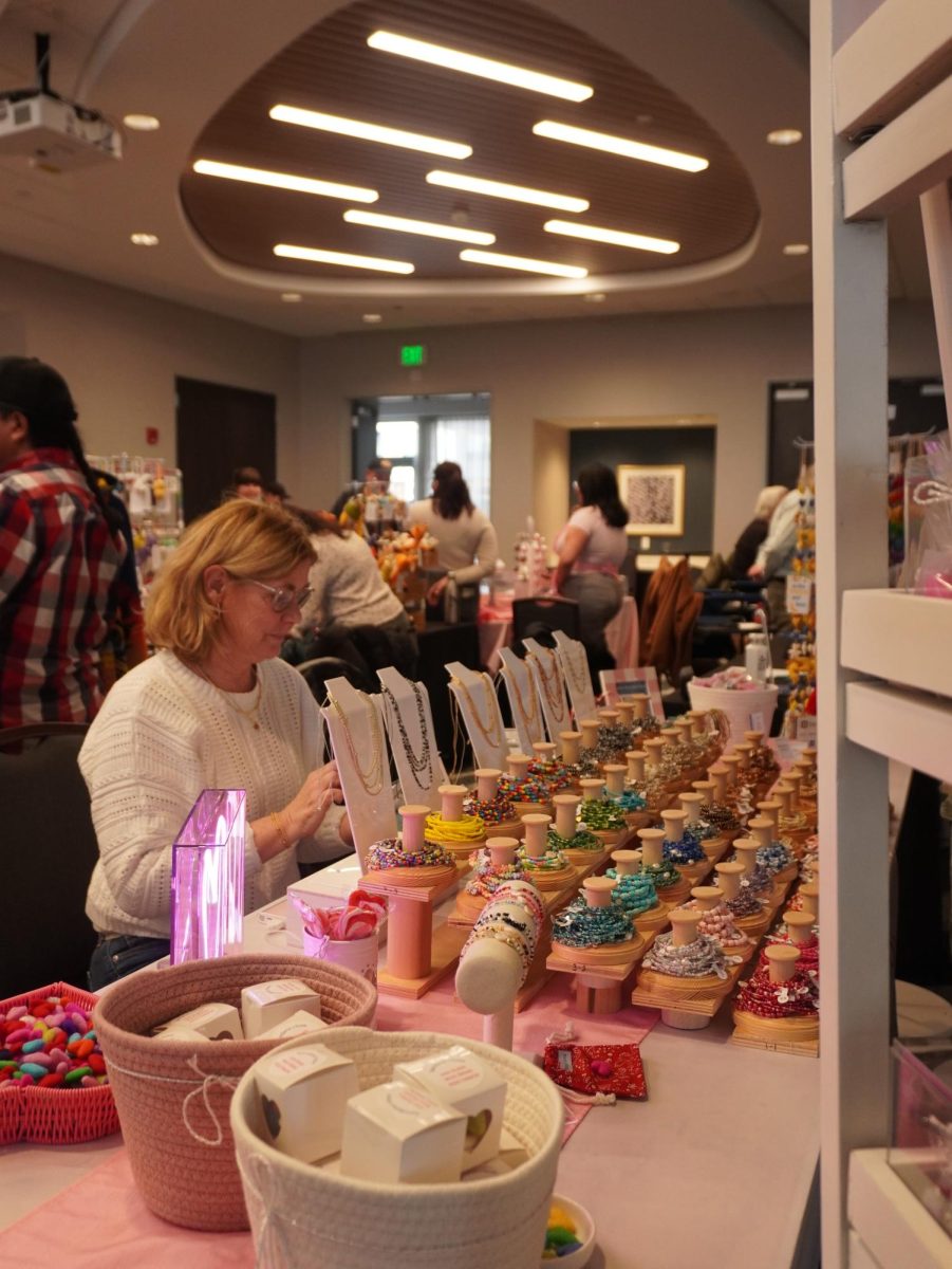 A woman running a jewelry stand completes a transaction. In contrast to the Sand Sculpting Festival, Winter Wonderland was split up into more definitive areas.