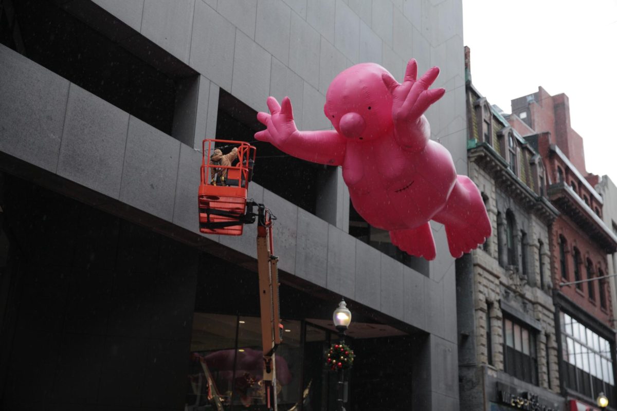 "Mr. Pink 6" by Philippe Katerine hands above Winter Street. The inflatable pink sculpture was part of a series of six similar sculptures placed around Downtown Boston.