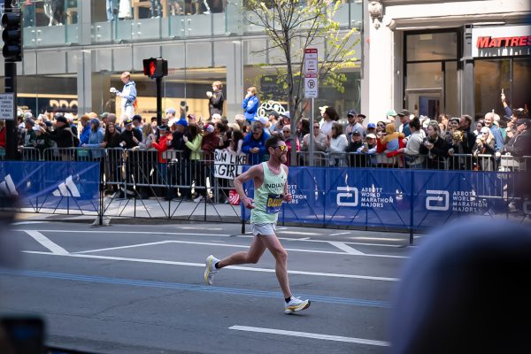 Jesse Davis makes his way past eager crowds on Boylston Street as they snap photos from behind barricades. The marathon attracted runners and spectators from across the country and around the world.