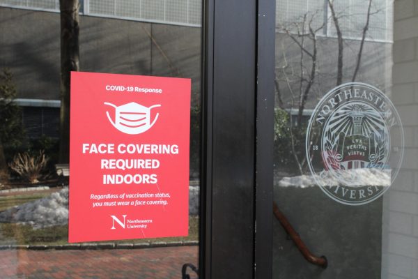 A sign reading "Face covering required indoors" next to the Northeastern University logo Feb. 8, 2022. COVID-19 shifted the goals and priorities of students to include focusing more on family and finding new hobbies. File photo by Marta Hill.