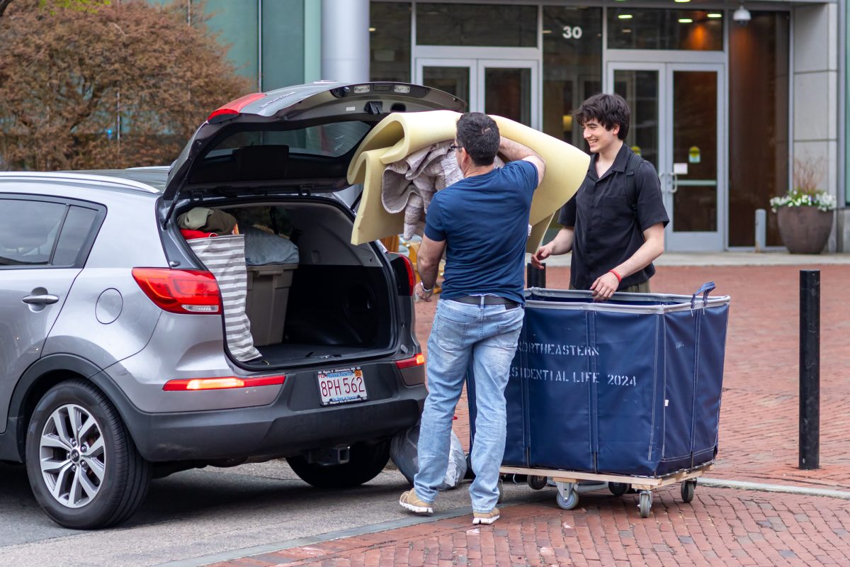 A student helps their family pack a car with mattress pads, pillows and laundry. Students recommended a range of amenities, such as mini fridges and fans, for incoming Huskies residence hall needs.