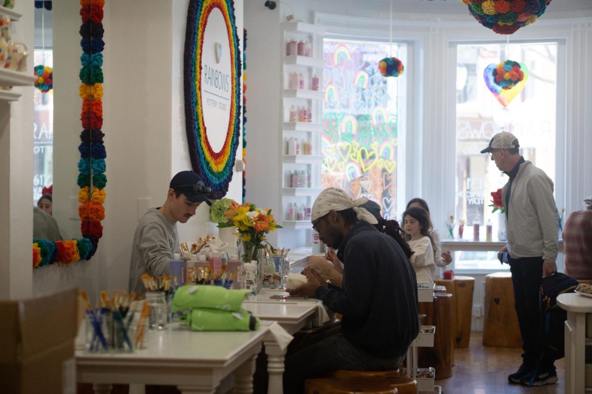 Family and friends paint pottery together at Rainbow Pottery.