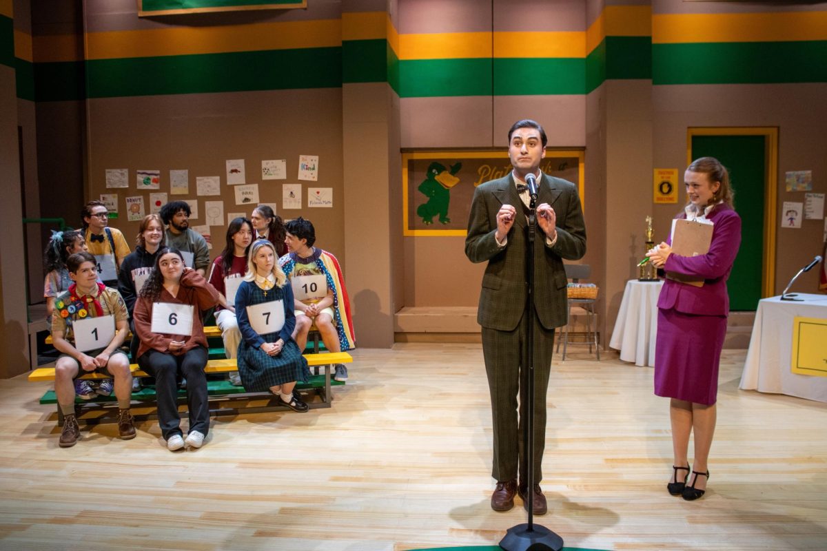The "25th Annual Putnam County Spelling Bee" cast and invited audience members gather for the competition, sitting on bleachers and announcing the rules. The show included colorful costumes that matched each character's backstory. Photo courtesy Ashley DiLorenzo.