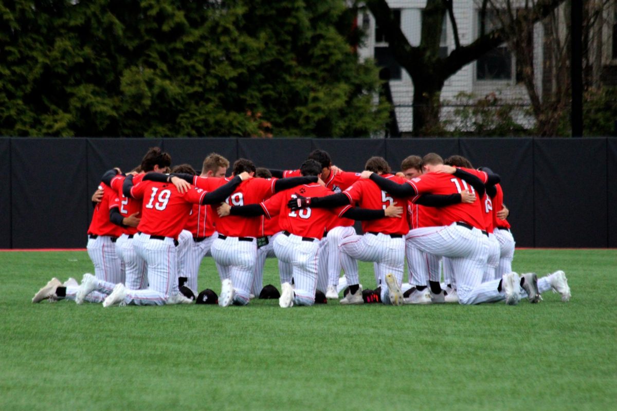 The team huddles before the game April 13. The Huskies swept the University of Delaware in a three-game series.