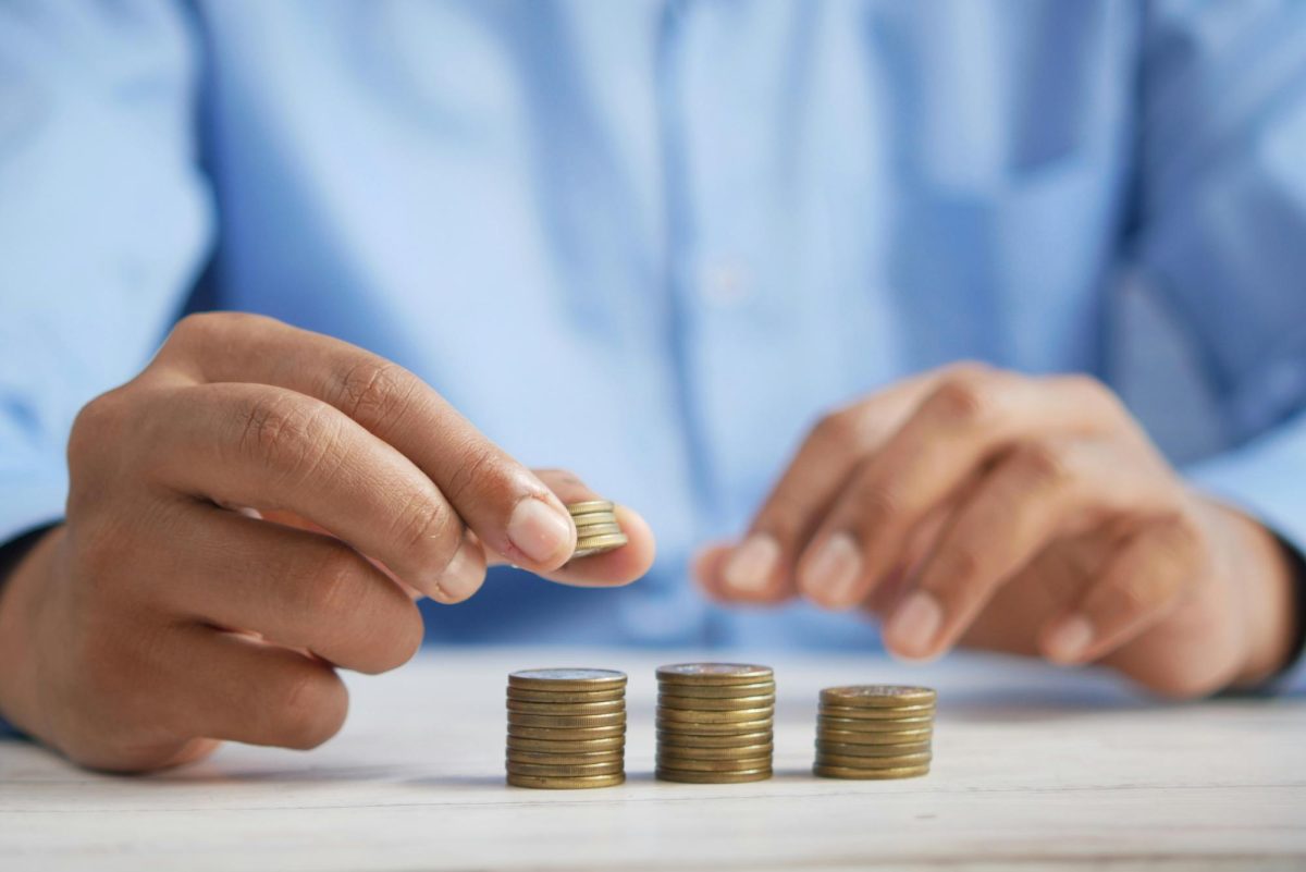 A person counts coins by placing them in stacks. Most school curriculums lacked important classes about money management and taxes, leaving students feeling lost in financial burden. Photo courtesy Towfiqu Barbhuiya on Unsplash.
