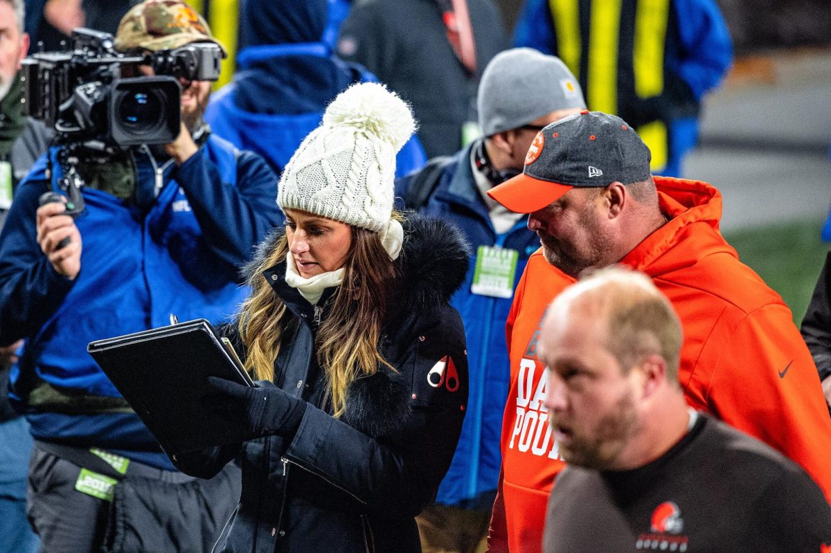 Sports journalist Erin Andrews (left) jots down North Carolina Tar Heels Offensive Coordinator Freddie Kitchens' strategy opinions during a game Nov. 14, 2019. According to a 2022 Pew Research Center study, only 15% of sports journalists identified as women. Photo courtesy Eric Drost, Flickr.