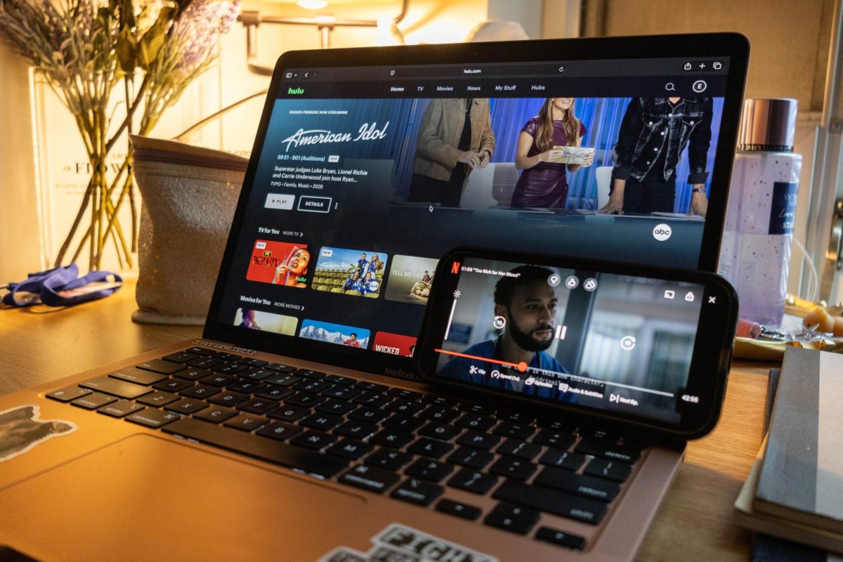 A computer and a phone use Hulu and Netflix streaming services respectively. Companies such as Netflix, Disney+, Amazon Prime Video and Peacock grew to dominate the streaming service landscape.