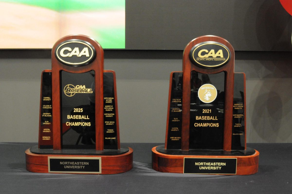 Two CAA Championship trophies sit on a table. The team received its CAA Championship rings Jan. 31.