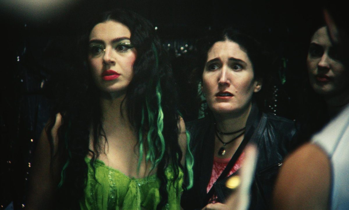 Charli XCX (left), dressed in a green concert outfit, and Molly (Kate Berlant) stress about a credit card promotion contract breach. XCX produced the mockumentary to reflect her fear of losing relevance after her hit album, "BRAT." Photo courtesy A24.