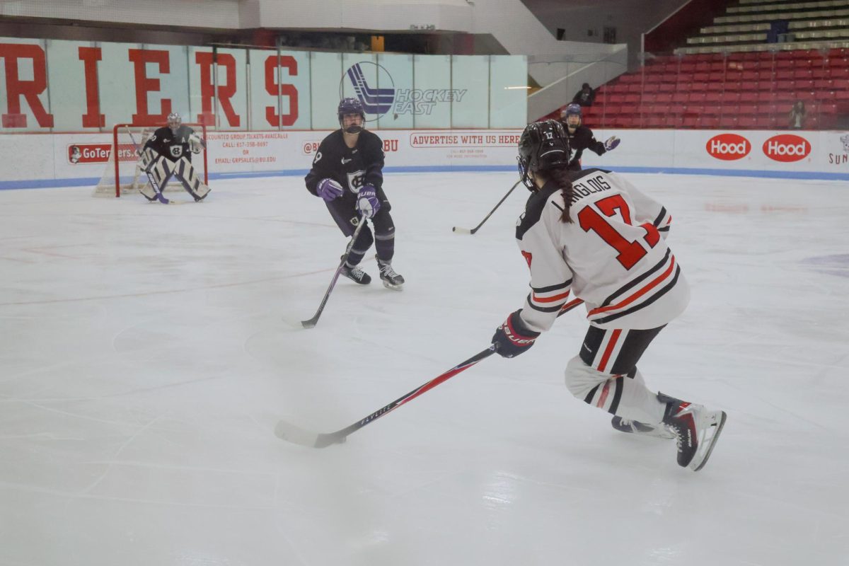 Mia Langlois takes on two opponents Jan. 29. The Huskies beat Vermont 3-2 in overtime, clinching the Hockey East regular season title.