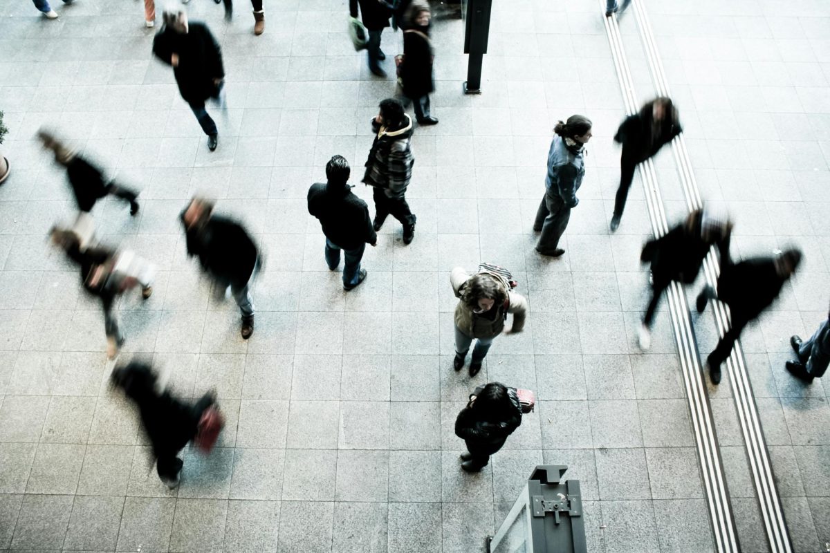People move across a concrete floor on their way to work. Movies and television series such as "The Wolf of Wall Street" and "Suits" often exaggerate corporate life. Photo courtesy Timon Studler, Unsplash.