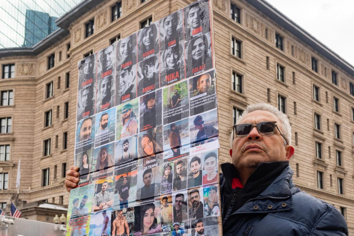 Ali Sarmadi carries a poster showing the faces of young Iranians killed for opposing the Islamic Republic regime Feb. 14. Read more here.