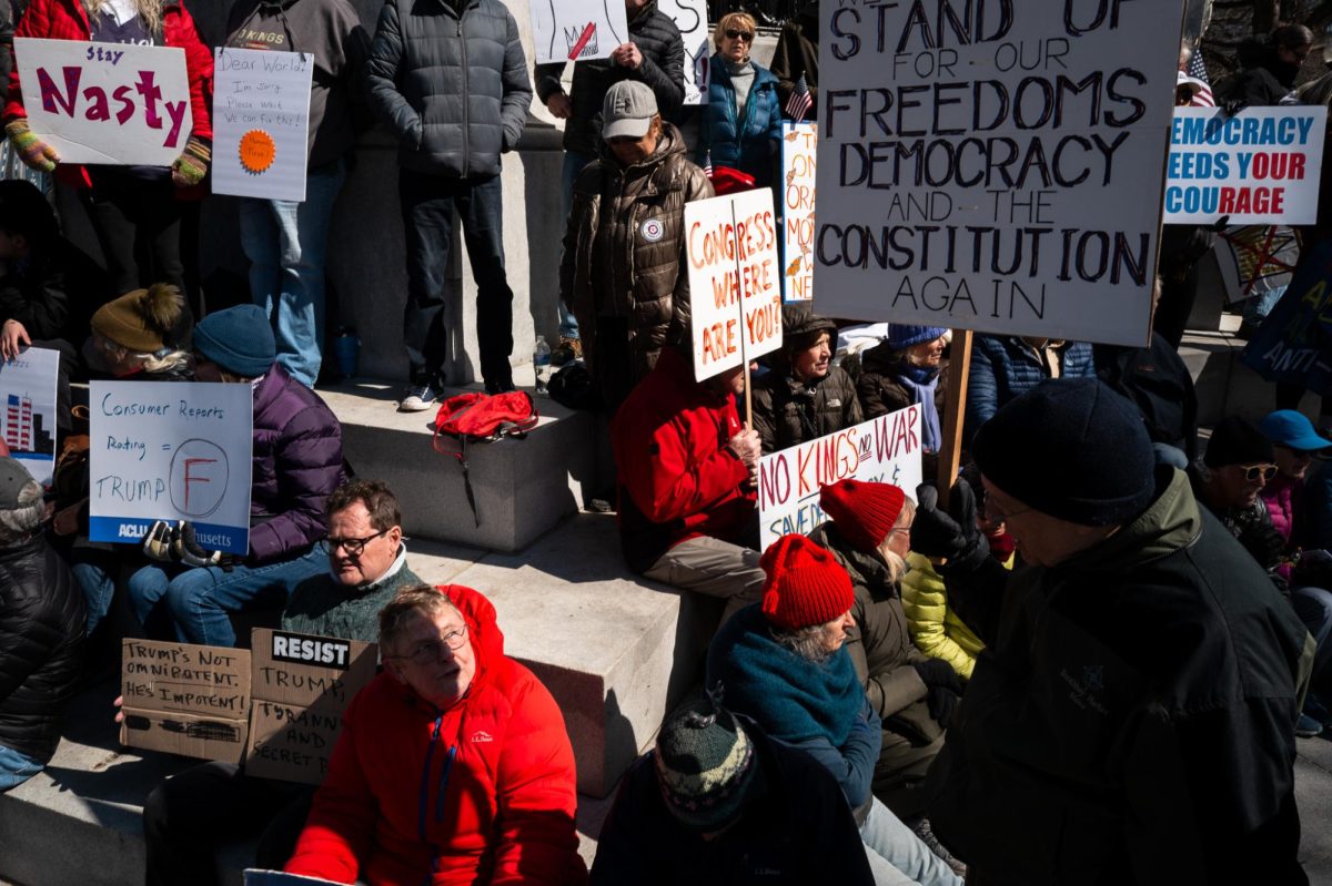 Protesters rest on the Soldiers and Sailors Monument. Protesters created multiple poster-making areas in the Common.