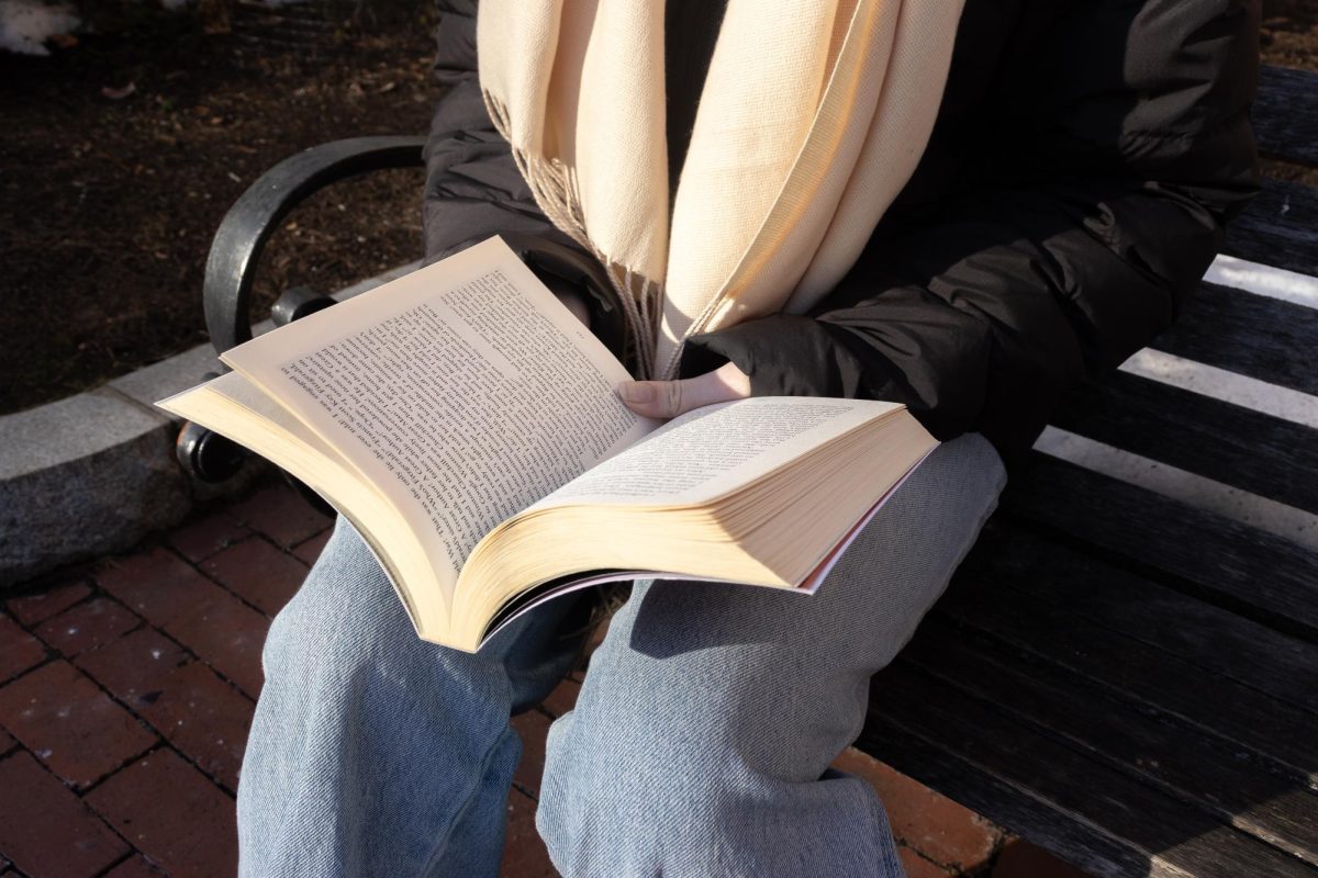 A student reads a book on a bench Feb. 24. Hobbies like reading or book clubs can give students a break from academic pressures.