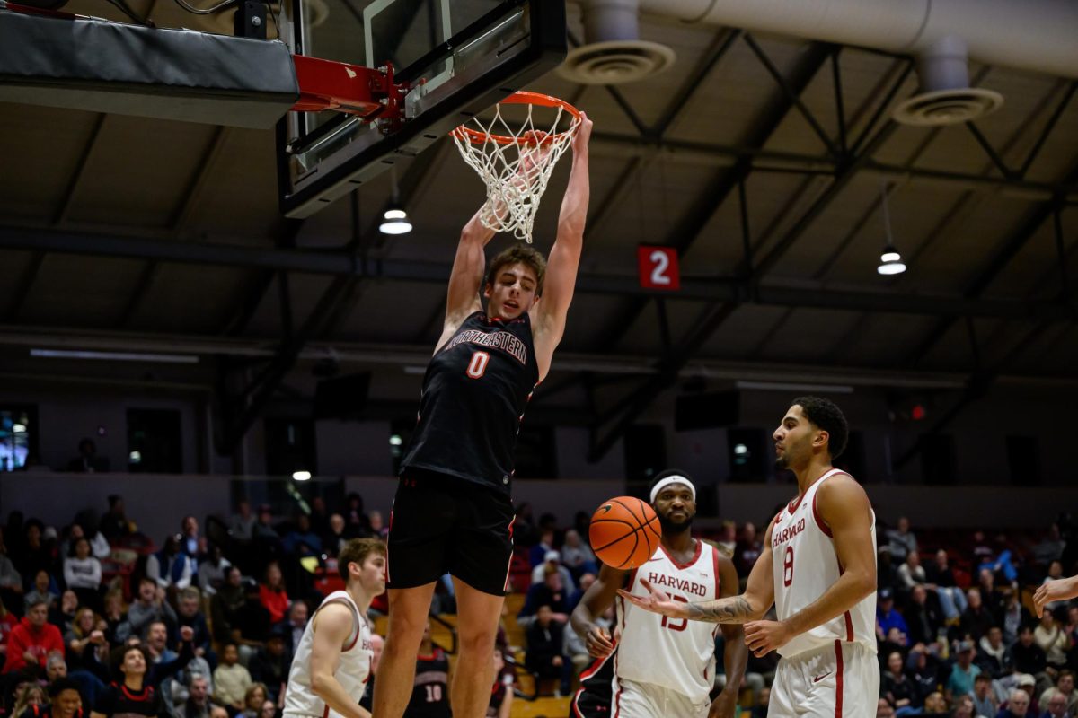Redshirt freshman forward Xander Alarie swings on the net over Harvard Nov. 11, 2025. Alarie scored 113 points in his single season as a Husky.
