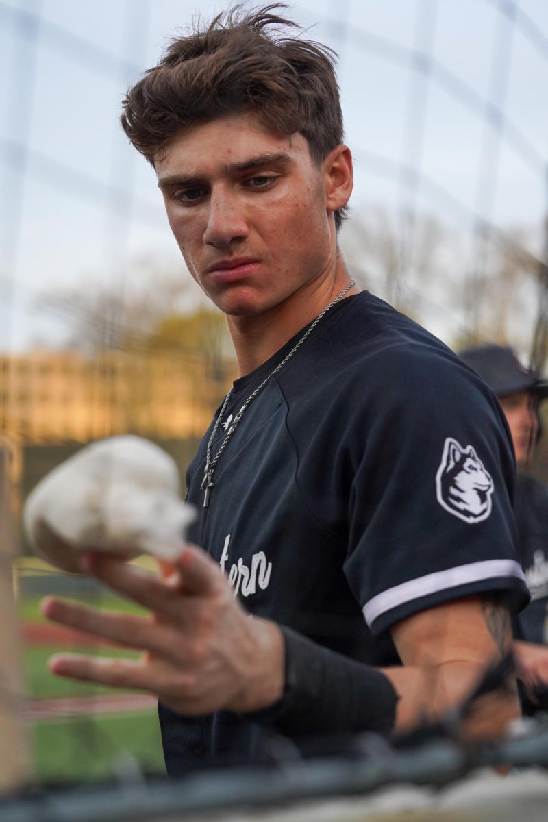 A Northeastern player holds a bag on his finger in the dugout during the Beanpot game against Boston College April 14. here.