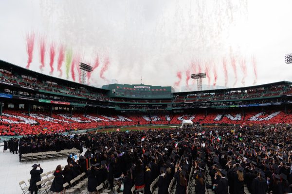  Fenway Park erupts in cheers and fireworks as Northeastern graduates celebrate the end of the 2026 commencement ceremony. Audience members coordinated a red and white signage surprise for the graduates reading, "Dream big NU."