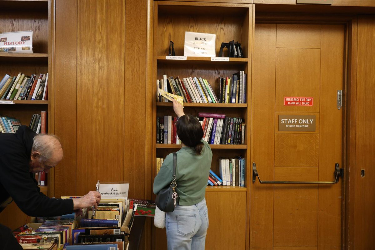 A customer grabs a book from a shelf at the City-Wide Friends’ bi-monthly book sale at the Boston Public Library April 4. Read more here.