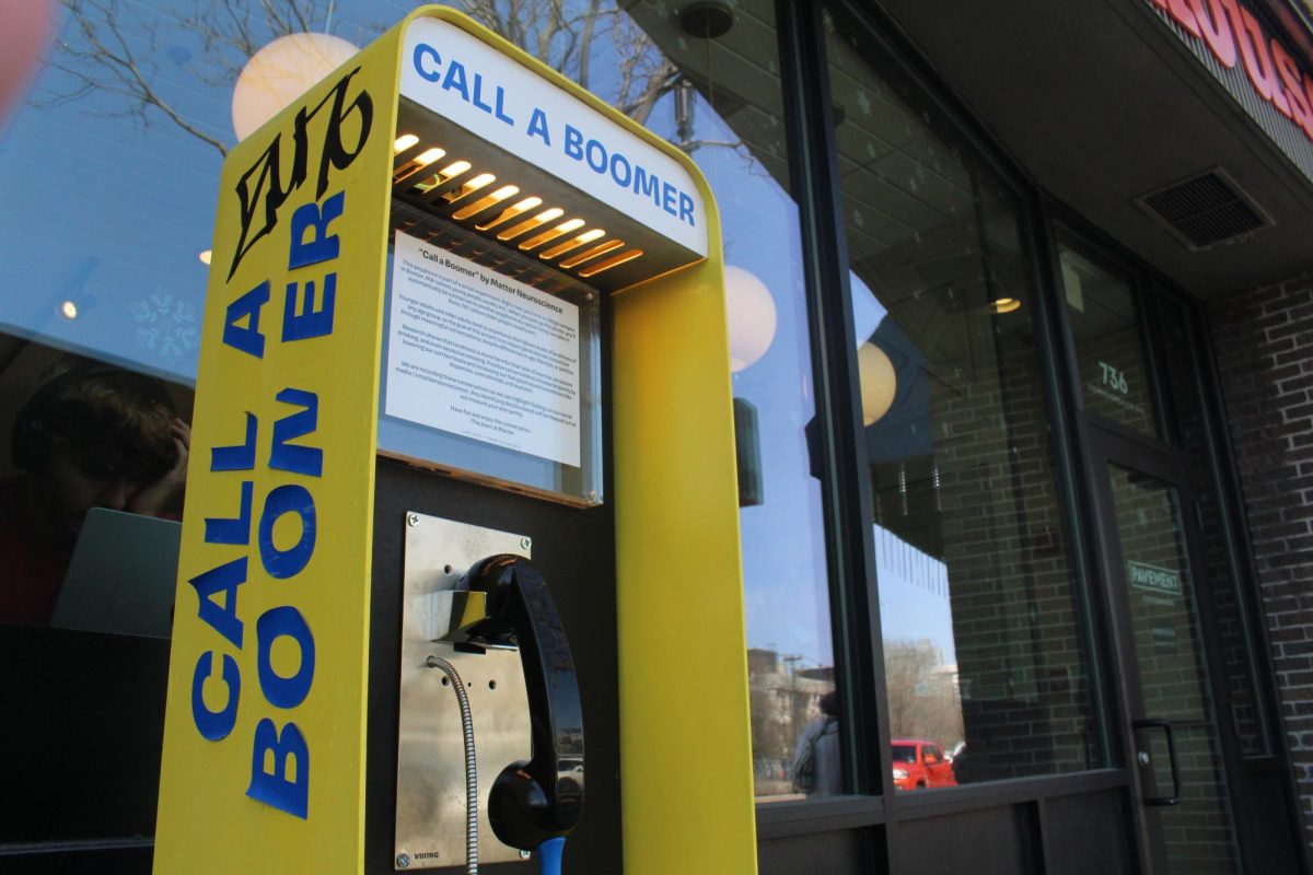 A “Call a Boomer” payphone stands outside Pavement Coffeehouse near Boston University School of Theology on Commonwealth Avenue April 10. The interactive payphone project invited younger participants to speak with older generations.