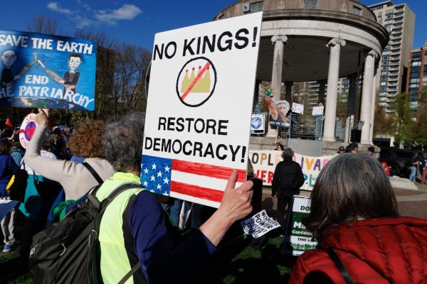 A protester hold a sign reading, "No Kings! Restore democracy" May 1. The demonstration was held to commemorate International Workers’ Day and to protest against the current administration.