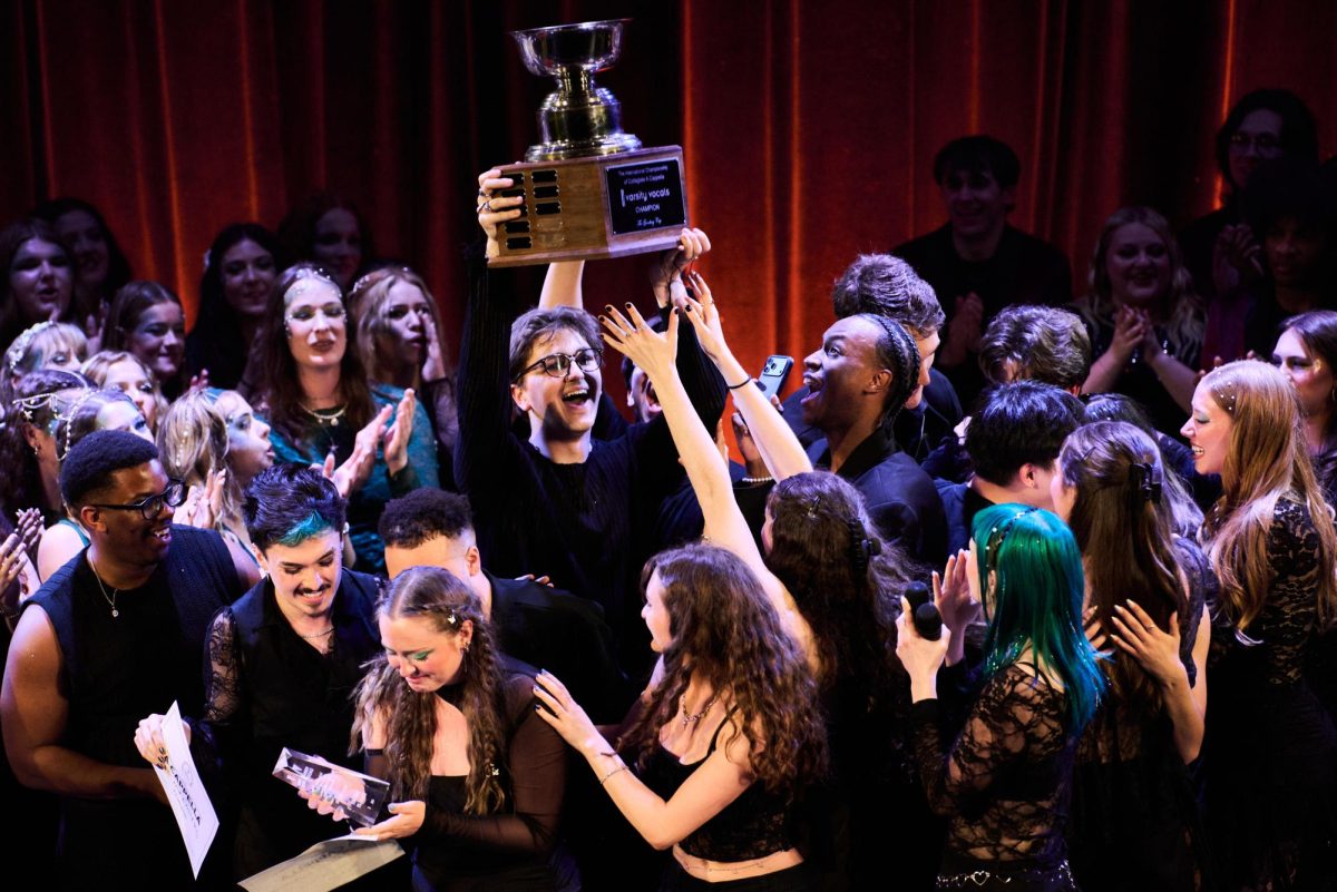 A member of the Nor'easters lifts the ICCA trophy after winning the competition April 25. The team garnered the second highest score in ICCA competition history, with a total of 447 points. Photo courtesy Ian Shiff.